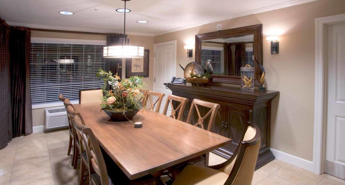 Interior view of Cedarbrook senior living community featuring a dining room with hardwood furniture and bay window.