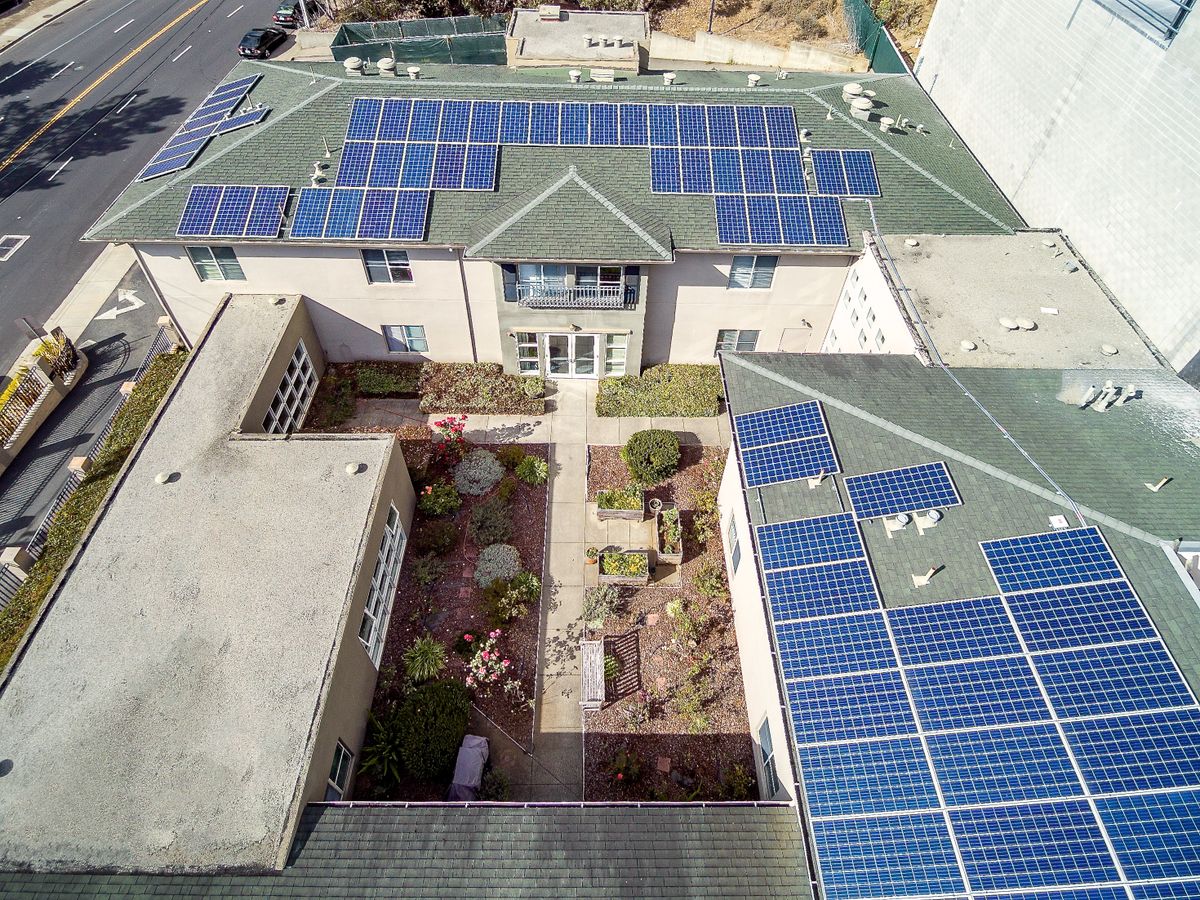 Aerial view of Pacifica Senior Living Mission Villa with solar panels, outdoor spaces, and vehicles.