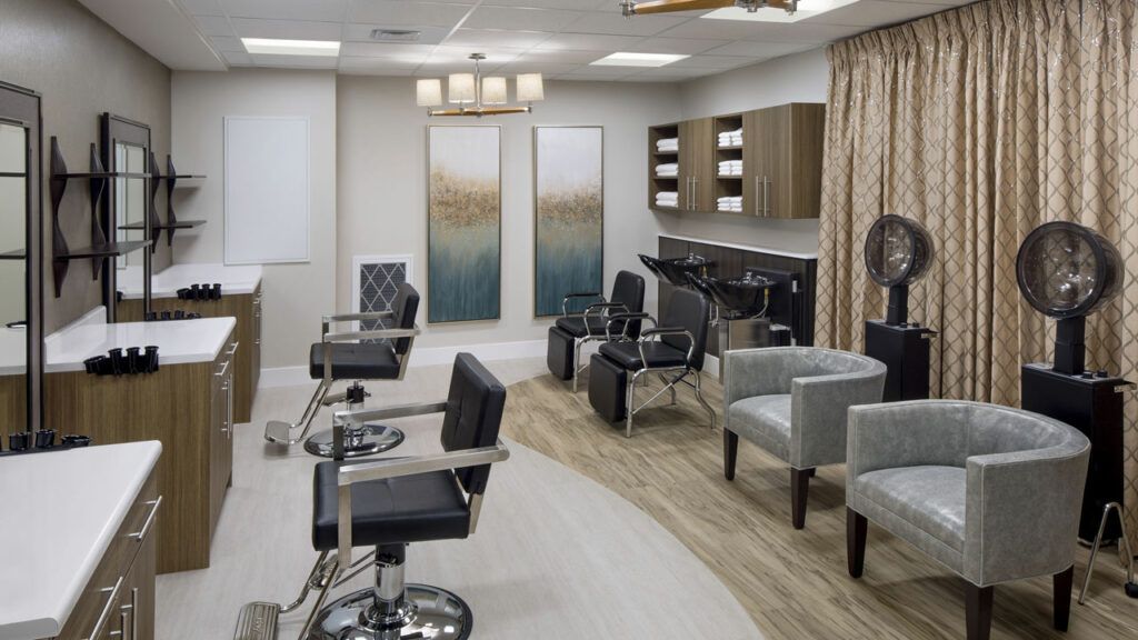 Indoor view of Belmont Village Senior Living Albany featuring a beauty salon, barbershop, and furniture.