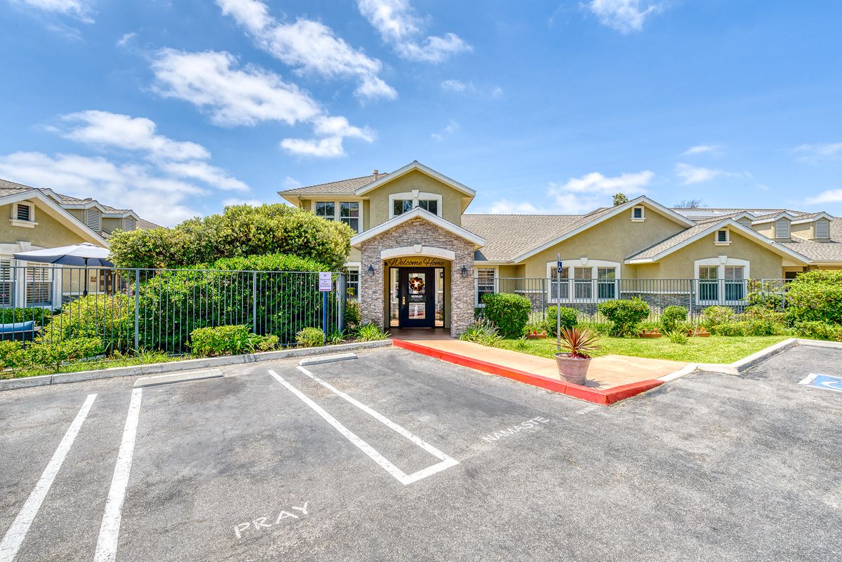 Neighborhood view of Pacifica Senior Living Newport Mesa, showcasing city architecture and lush plants.