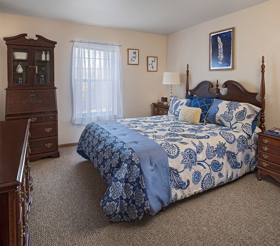 Interior view of a bedroom in American House Riverview senior living community with elegant decor.