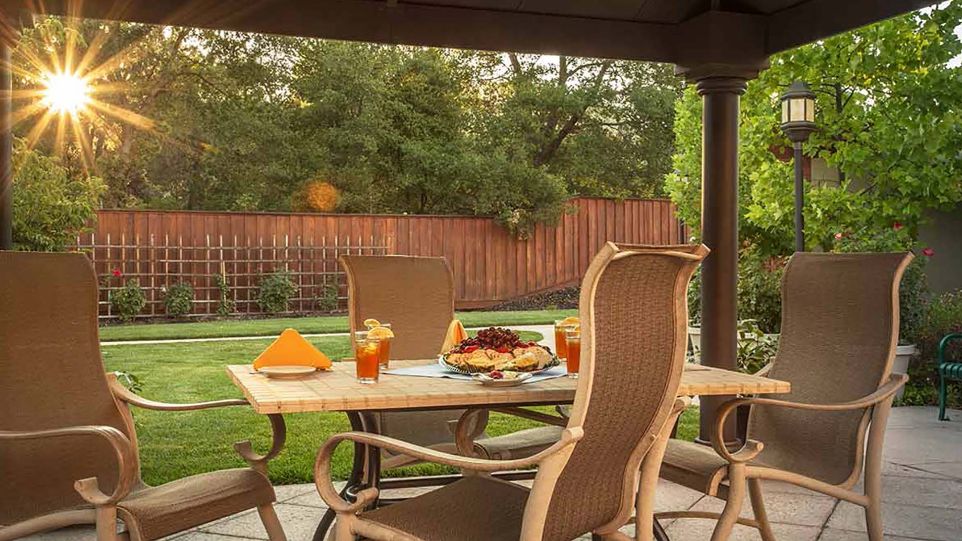 Senior living community Atria Park of Lafayette featuring outdoor yard, indoor dining area and patio.