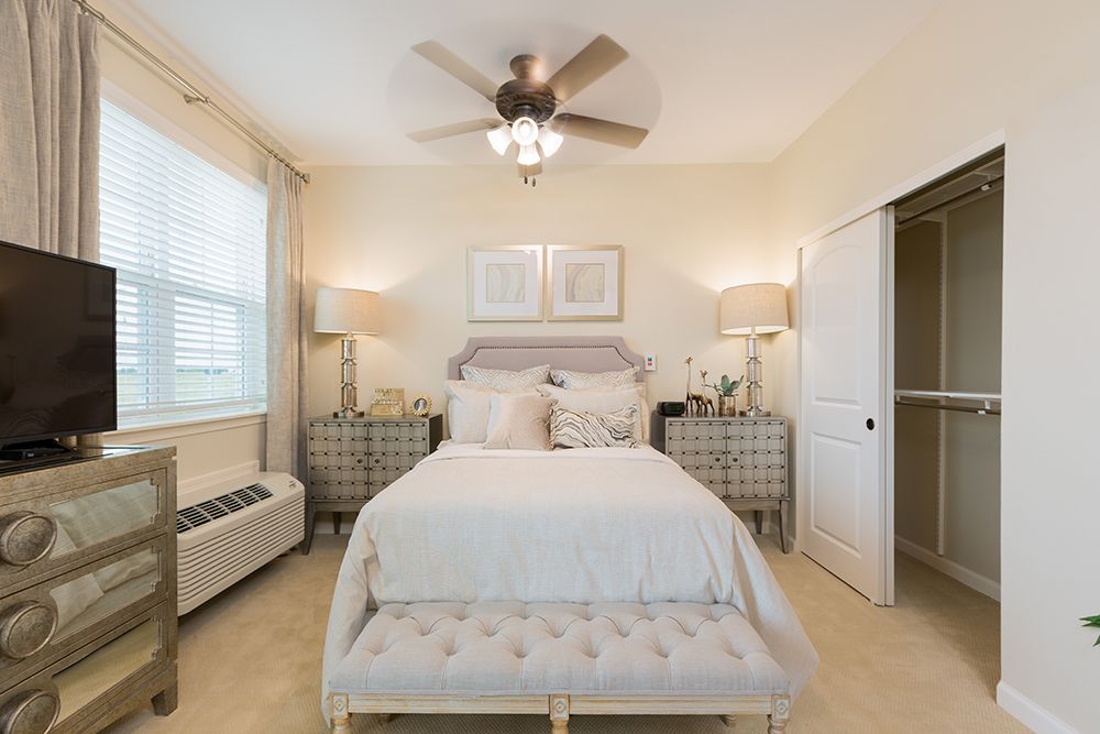 Interior view of a bedroom at The Enclave at Round Rock Senior Living with modern electronics.