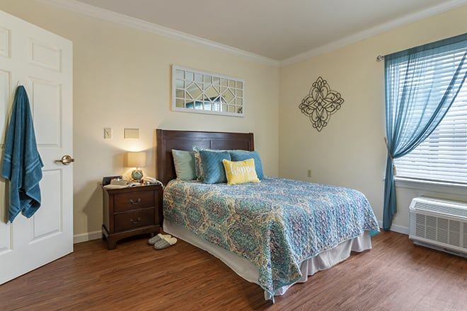 Interior view of a furnished bedroom at Brookdale Spring Shadows senior living community.