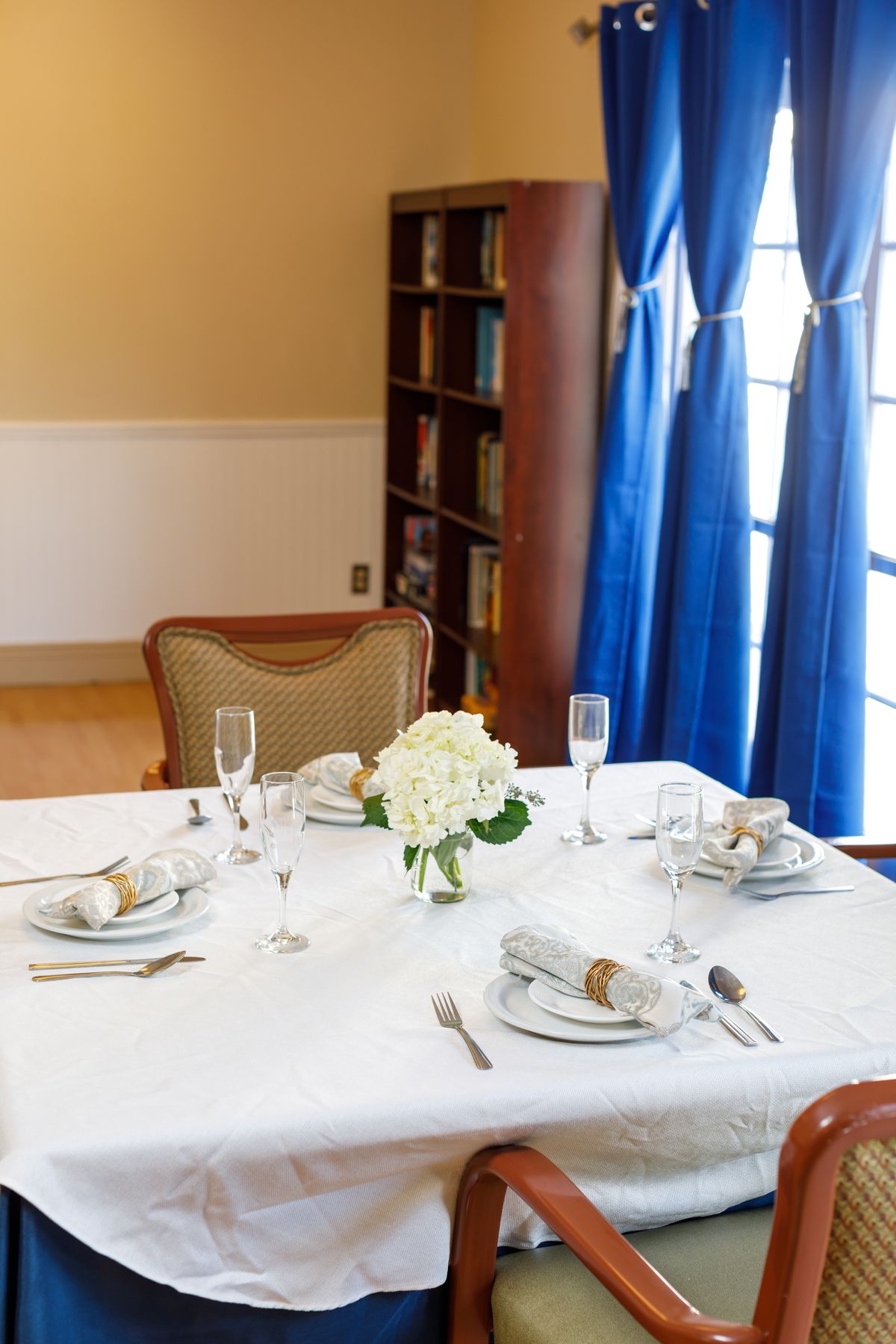 Elegant dining room setup at Ocean Pointe Healthcare Center with floral decor and food.