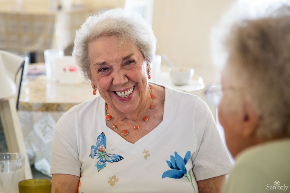Happy senior woman laughing in Burbank Retirement Villa East, adorned with jewelry.