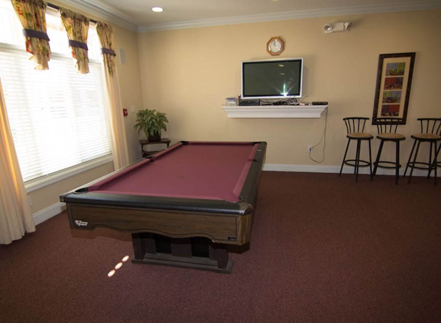 Seniors enjoying a game in the billiard room with TV and computer facilities at Independence Village.