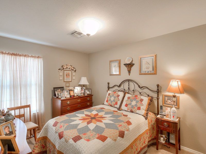 Senior living bedroom interior at Azalea Estates of New Iberia with cozy decor and furniture.