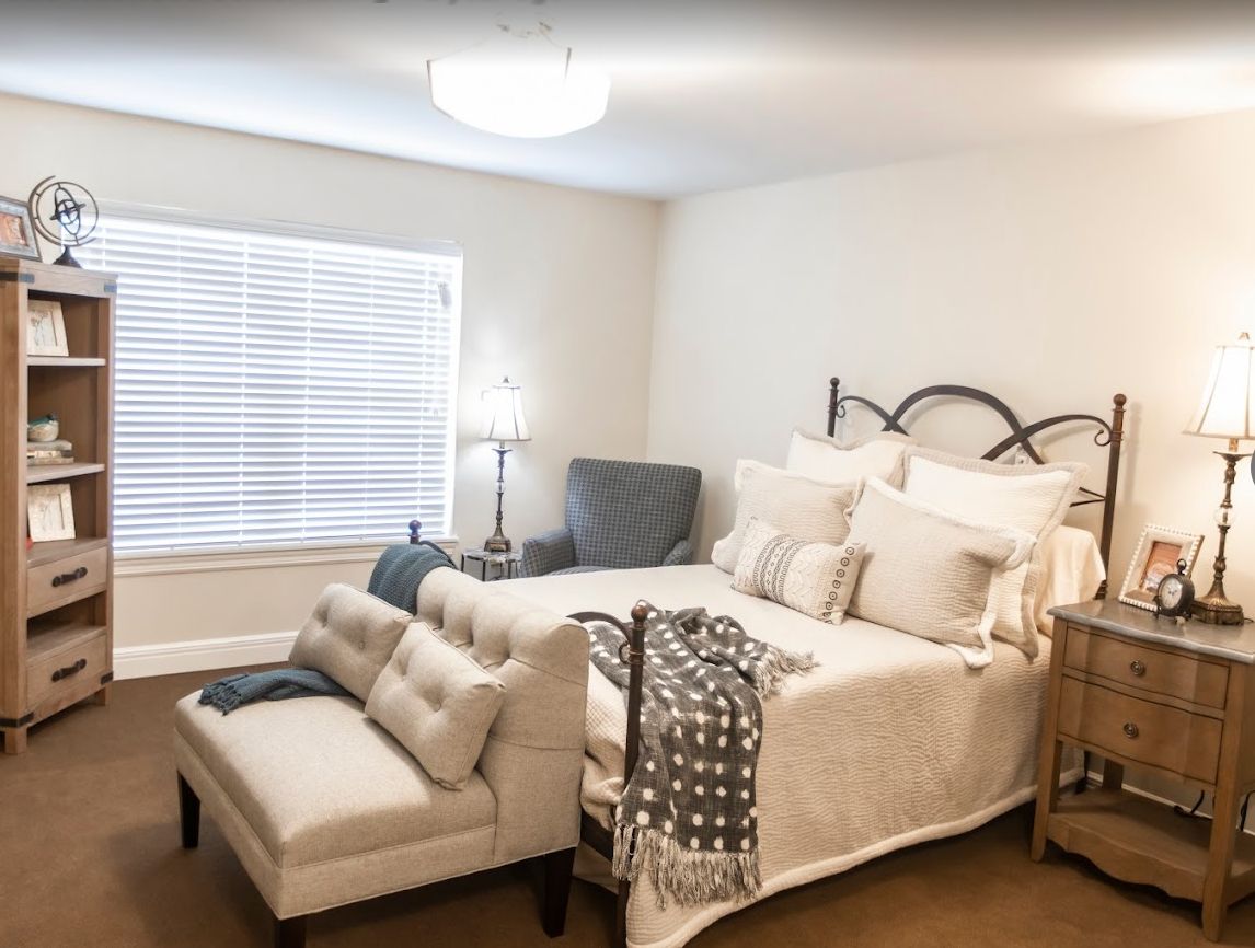 Interior view of a cozy bedroom at The Wildwood Senior Living with elegant furniture and decor.
