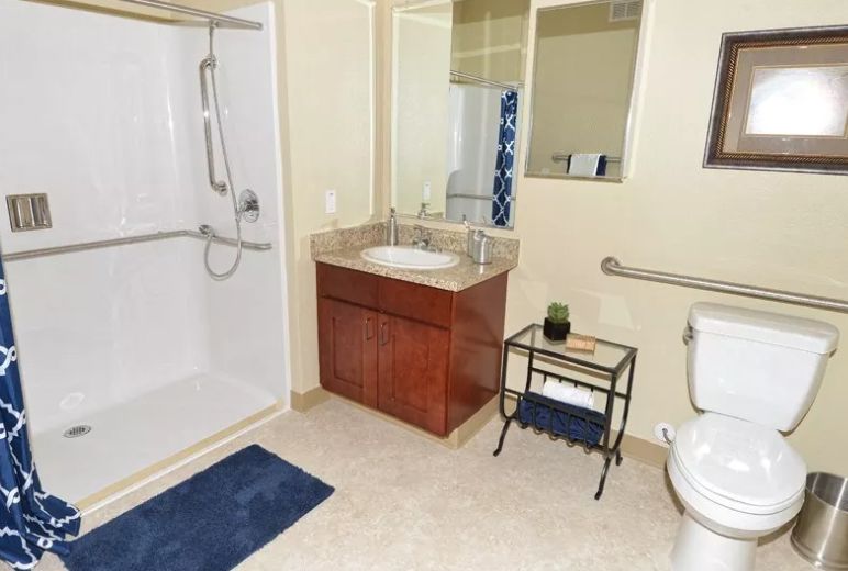 Interior design of a room with a sink and bathroom in Caliche Senior Living community.