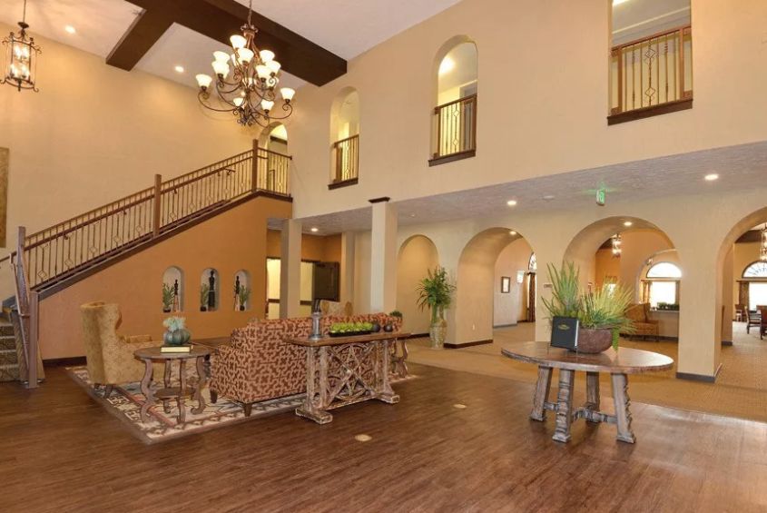 Caliche Senior Living community featuring elegant architecture, indoor dining room, and cozy living room decor.