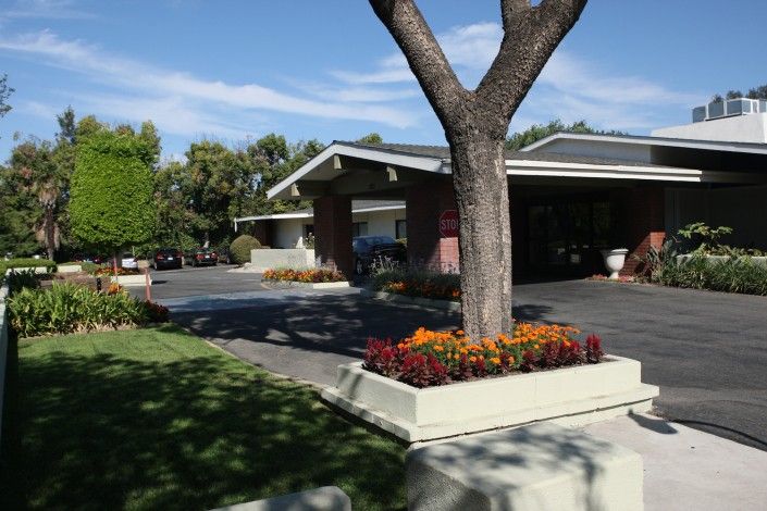 Upland Rehabilitation and Care Center, a senior living community with lush greenery and urban amenities.