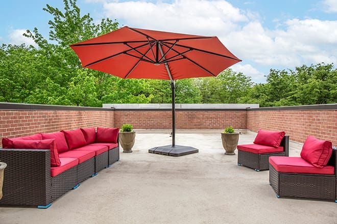 Brookdale Potomac senior living community featuring patio with furniture, canopy, and lush backyard.