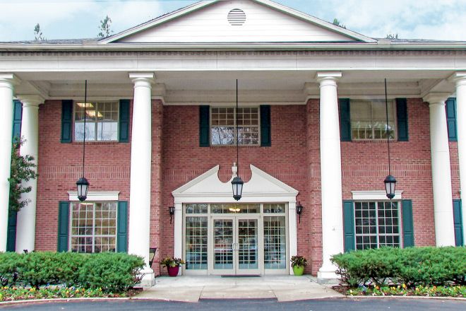 Brookdale Germantown senior living community featuring a portico, lush plants, and housing units.