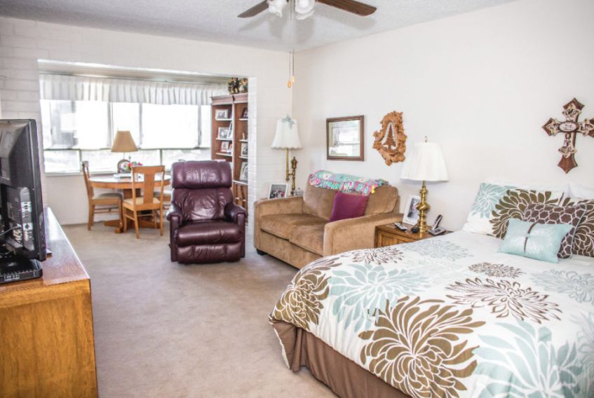 Senior living community room at Rowntree Gardens with modern furniture, electronics, and decor.