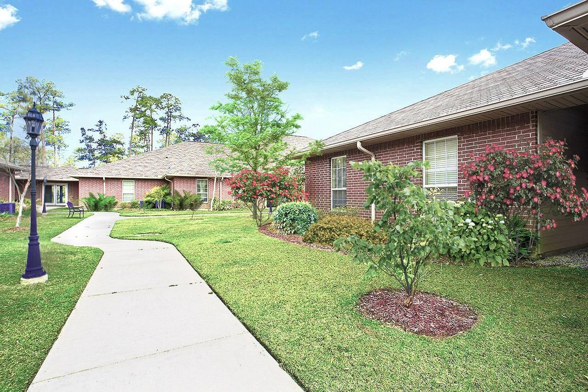 Summerfield Senior Living in Slidell, a suburban neighborhood with lush lawns, plants, and outdoor paths.