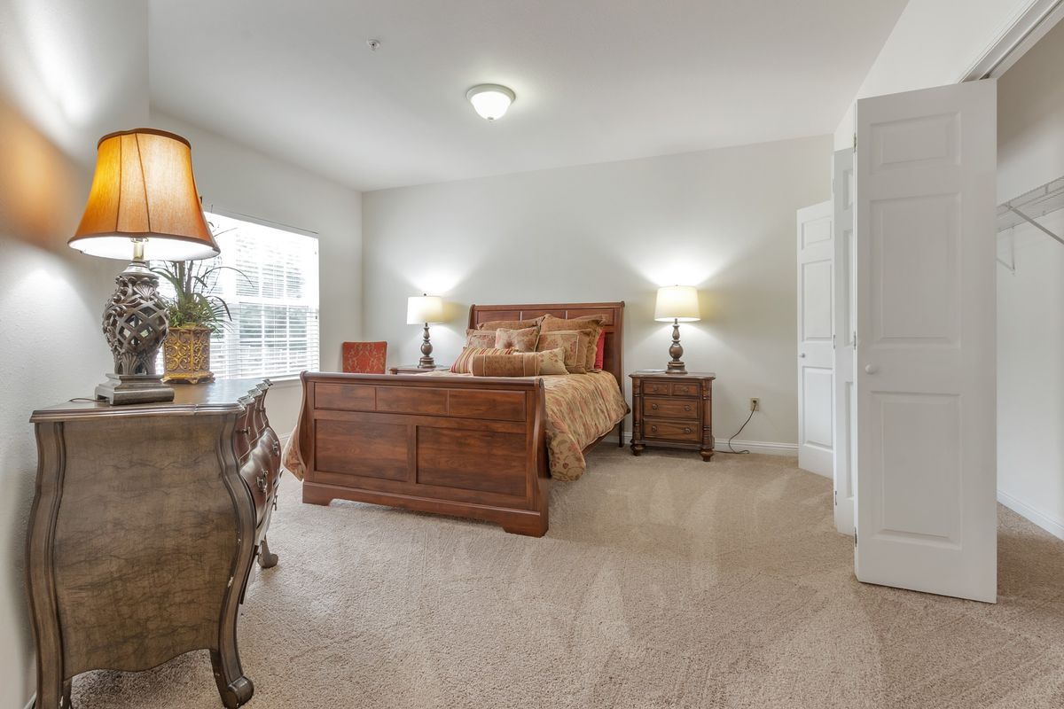 Interior view of a cozy bedroom in Town Village Tulsa senior living community with stylish decor.