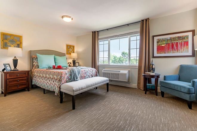 Interior view of Brookdale Auburn senior living community featuring cozy bedroom decor and furniture.