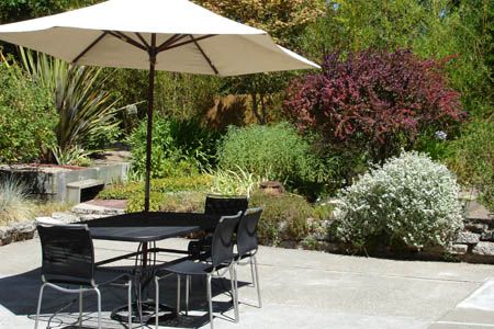 Senior living community, L'Chaim House II, featuring patio dining area amidst lush greenery.