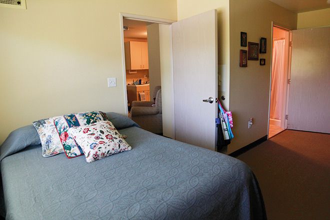 Senior living community bedroom at Creston Village featuring cozy furniture and home decor.