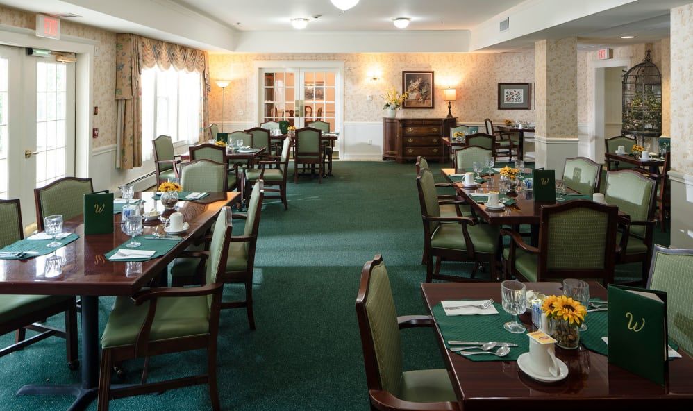 Senior living community Windham Terrace featuring dining room with art, furniture, and residents.