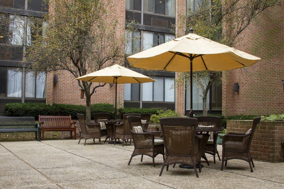 Senior living community in Montgomery Village with patio furniture, lush grass, and canopy.