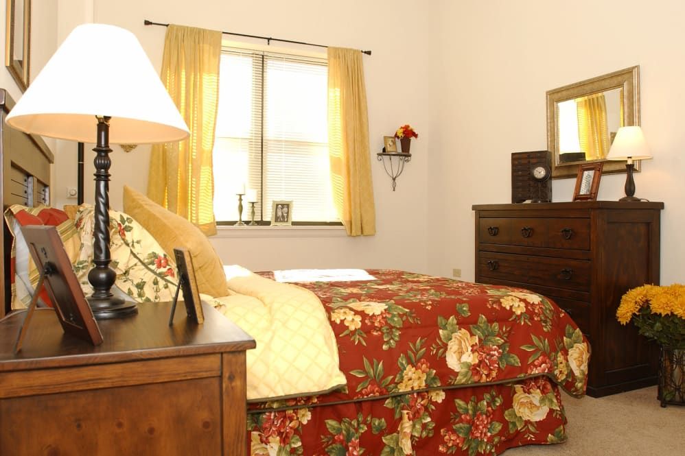Interior design of a bedroom in Green Oaks senior living community featuring art, home decor, and furniture.