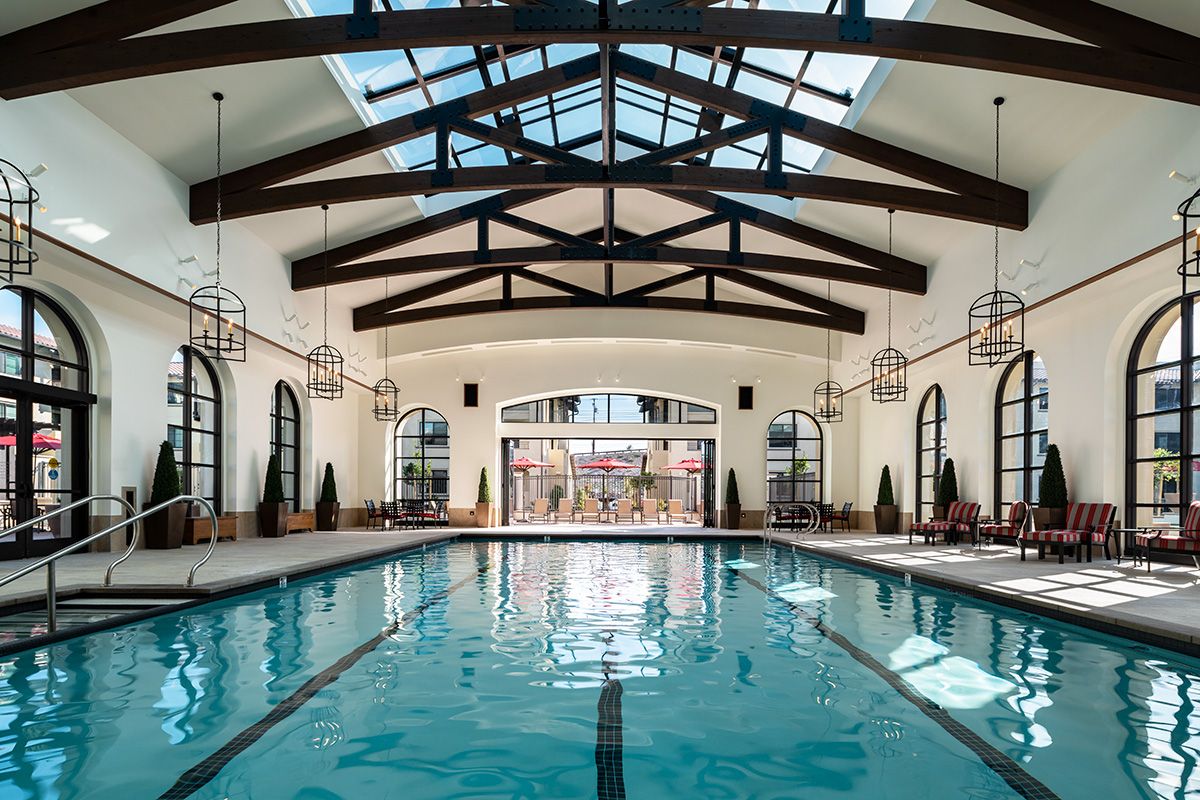 Outdoor swimming pool at Wisteria Warner Center senior living community with resort-style architecture.