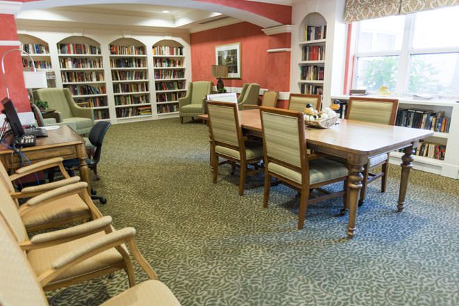 Interior view of Brookdale Deer Creek senior living community featuring library, dining room and decor.
