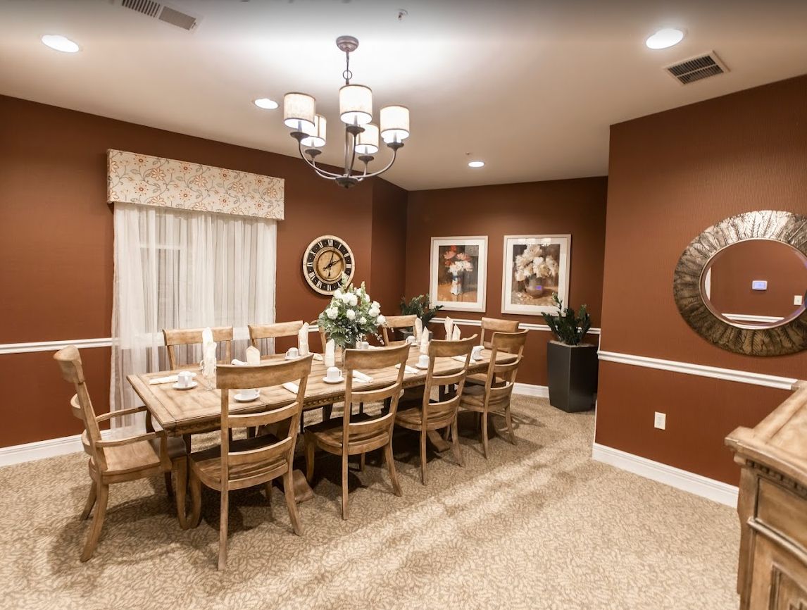 Interior view of The Wildwood Senior Living featuring elegant dining room with chandelier and art.