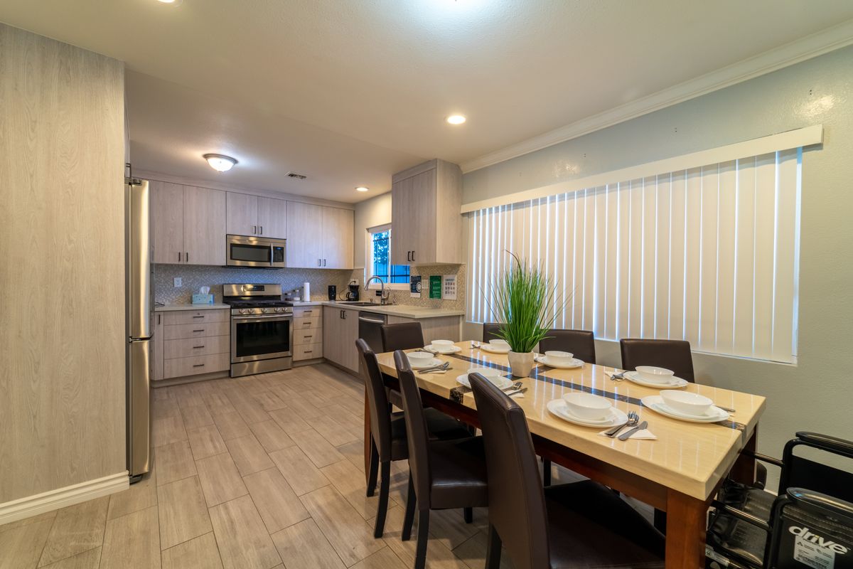 Senior living community interior featuring a well-designed dining room and kitchen with modern appliances.