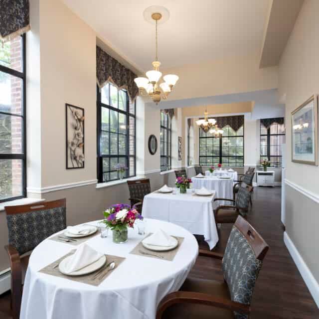 Senior living community dining room at Standish Village with art, decor, and residents.
