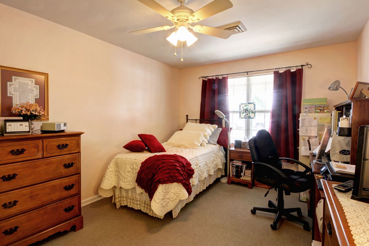 Interior view of a furnished bedroom in Madison Village senior living community with modern amenities.
