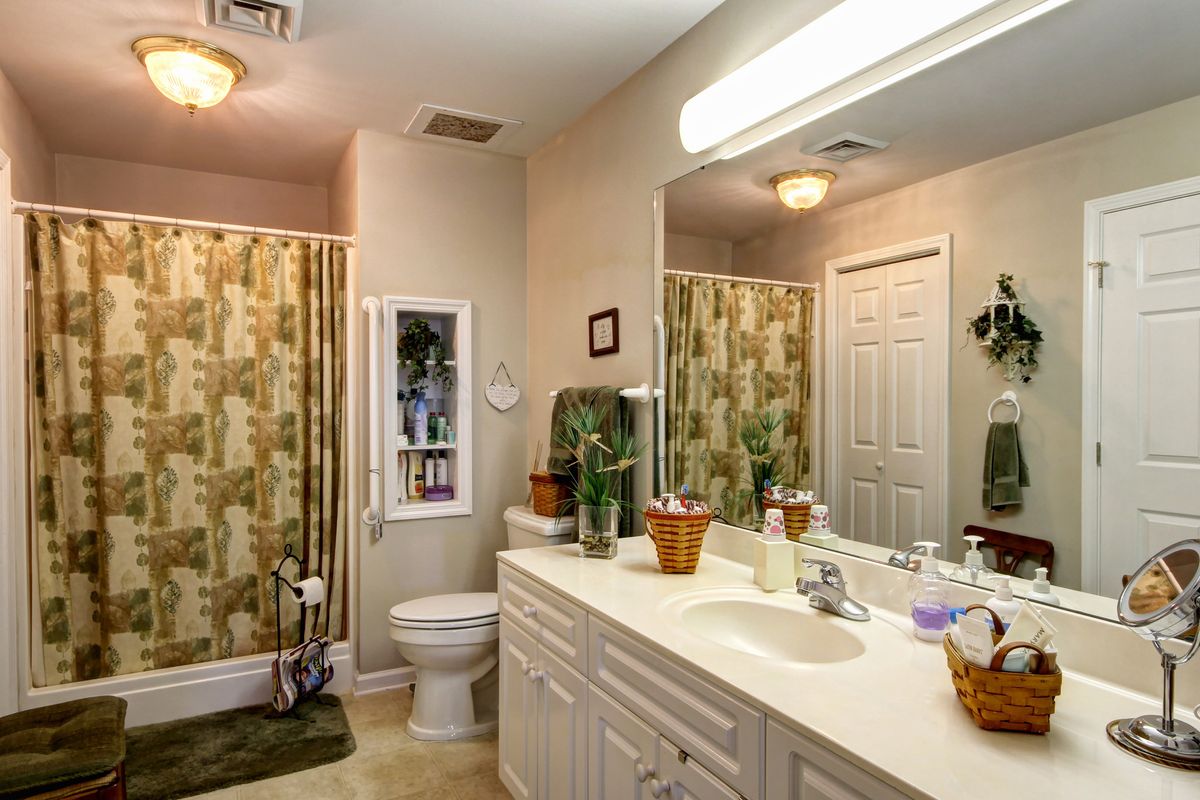 Interior view of Madison Village senior living community, featuring a well-decorated bathroom with double sink and art.