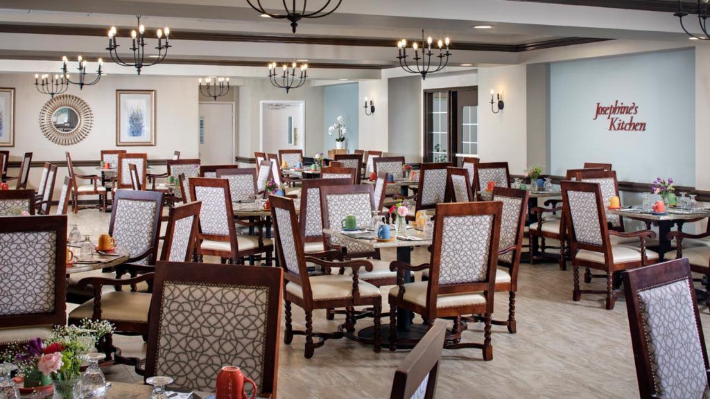 Belmont Village Senior Living San Jose featuring elegant architecture, dining room with furniture, art and chandelier.