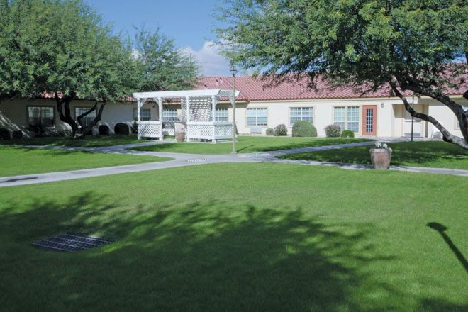 Brookdale Central Chandler senior living community with lush lawns, trees, and villa-style housing.