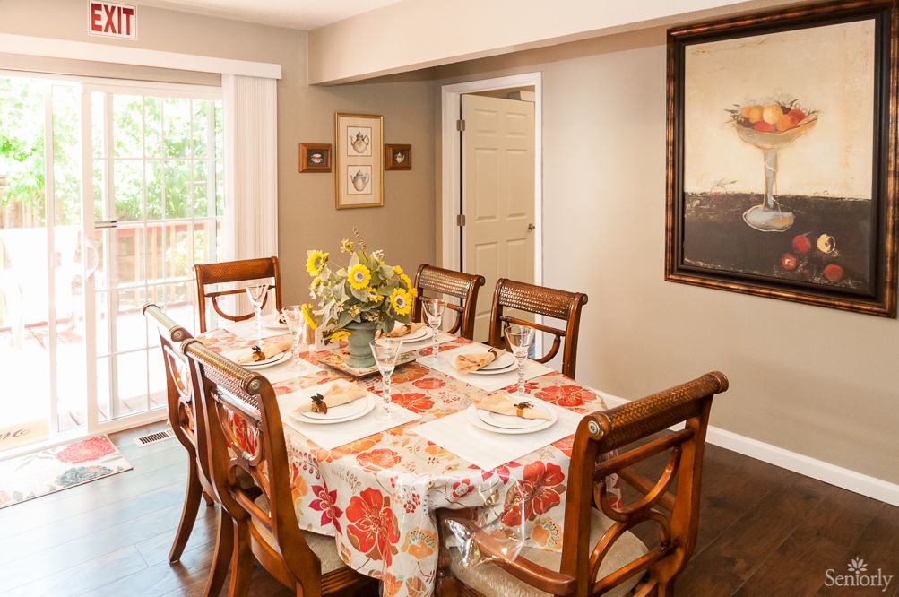 Interior view of Bermuda Residential Care Home featuring dining room with wooden furniture and floral decor.