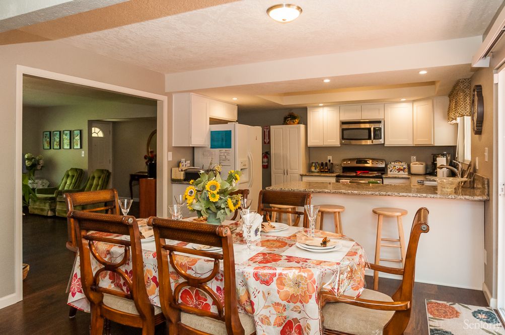 Interior view of Bermuda Residential Care Home featuring dining area, kitchen appliances, and decor.