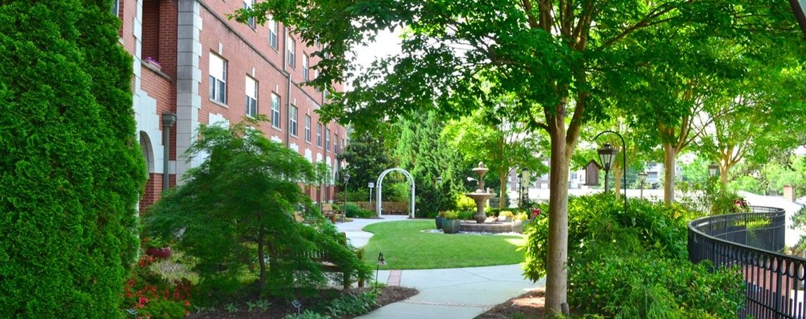 Senior living at King'sBridge Retirement Community, featuring lush gardens, high-rise apartments, and urban scenery.