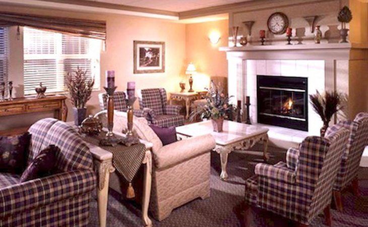 Senior living room at The Pointe at Kilpatrick with cozy furniture, fireplace, and art decor.