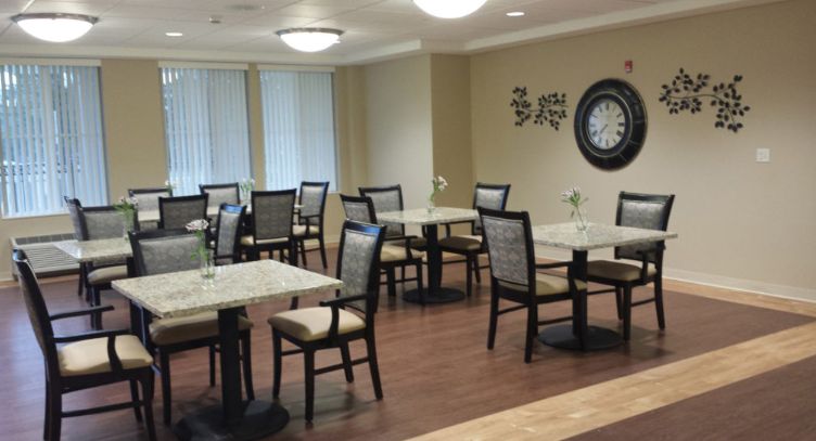 Interior view of Belmar Oakland senior living community featuring dining room with wooden furniture.