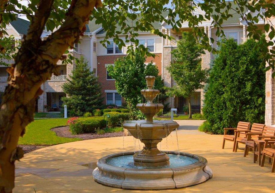 Smith Crossing senior living community with modern architecture, backyard fountain, and urban nature.