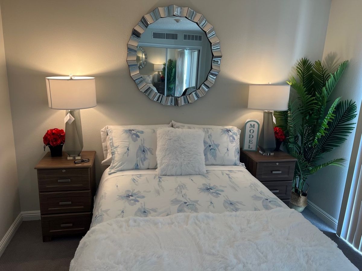 Senior resident enjoying a well-decorated bedroom with a lamp, plant, and furniture at Sparr Heights Estates Senior Living.