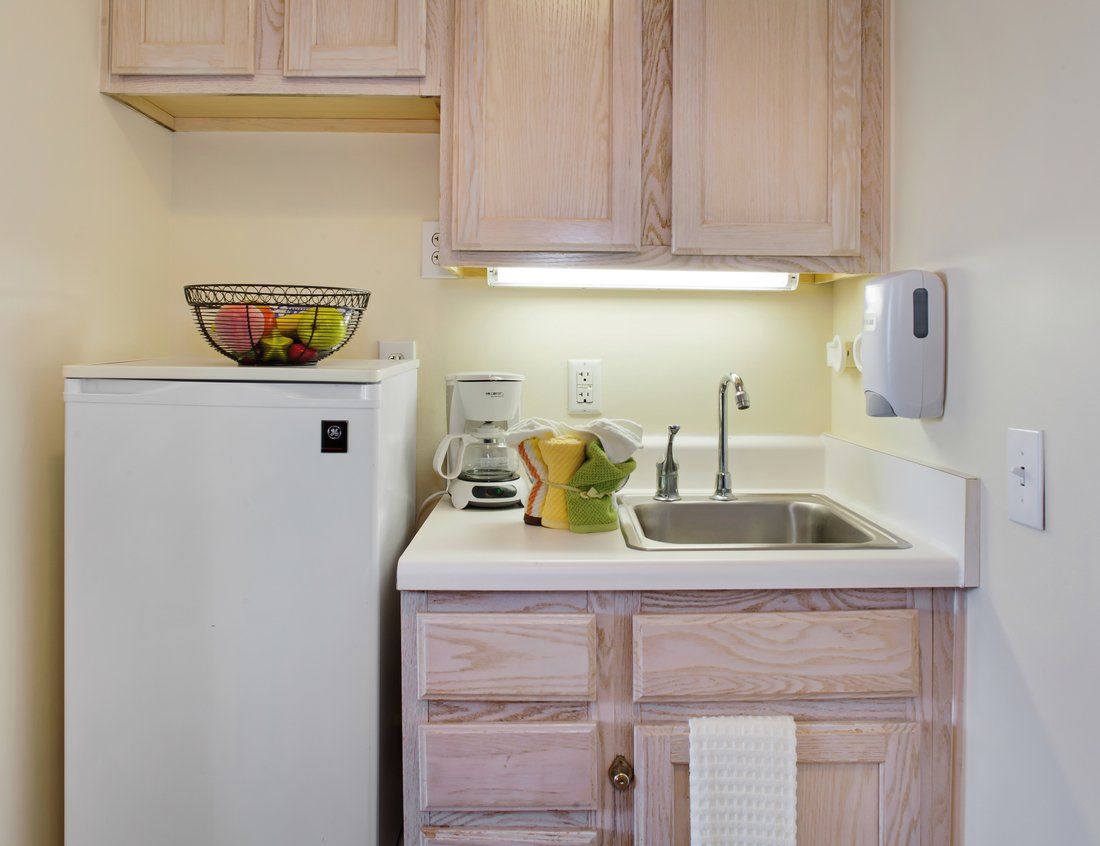 Interior view of a North Hills senior living community kitchen with modern appliances and fresh fruits.
