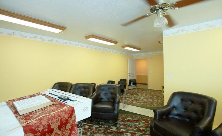 Senior enjoying a comfortable living room with modern furniture and electronics at Avista Senior Living.