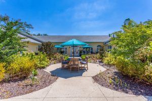 Charter Senior Living of Hermitage, a villa-style resort with outdoor patio and lush greenery.