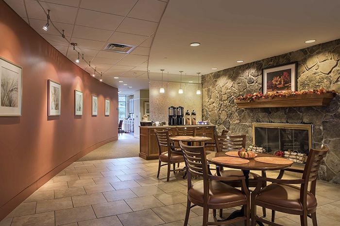 Interior view of AVIVA Country Club Heights senior living community featuring dining area and fireplace.