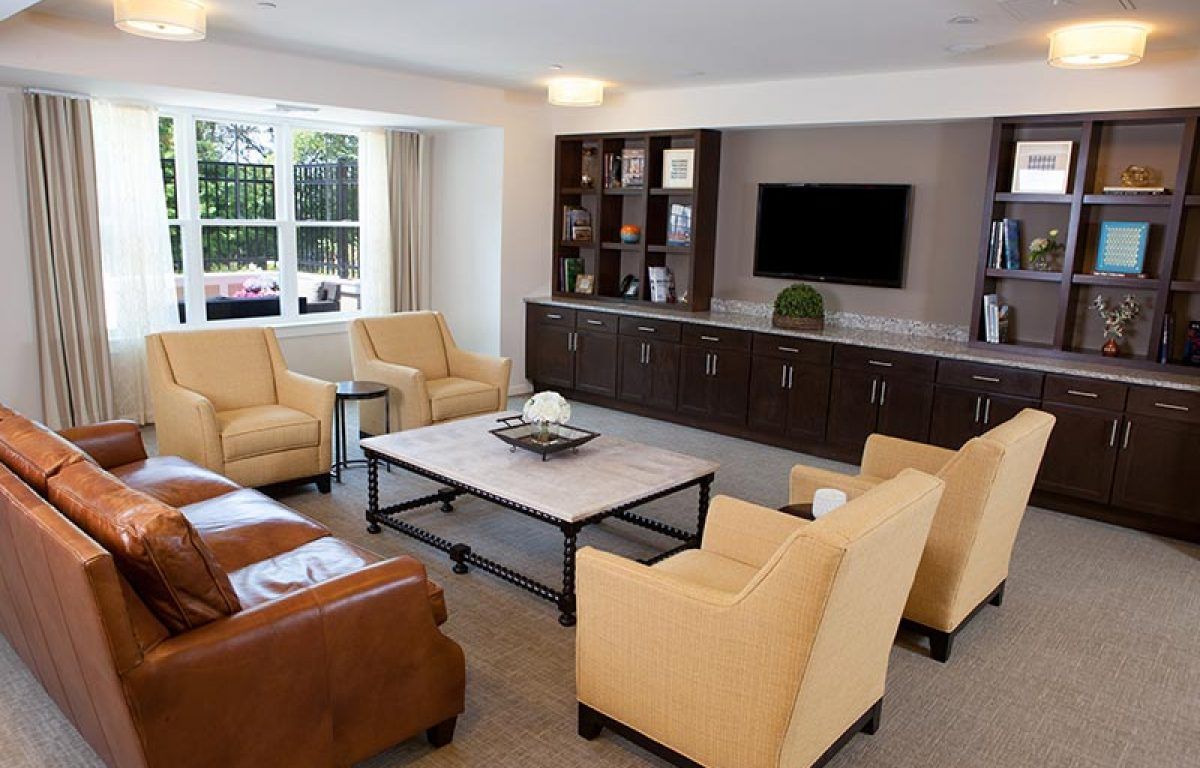 Interior of Wingate Residences at Needham, featuring modern living room with TV and furniture.
