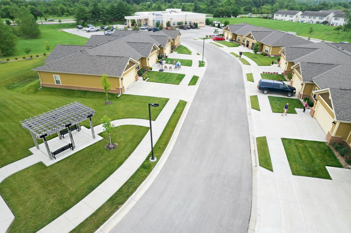 Aerial view of The Parkway Senior Living community featuring houses, driveways, and cars.