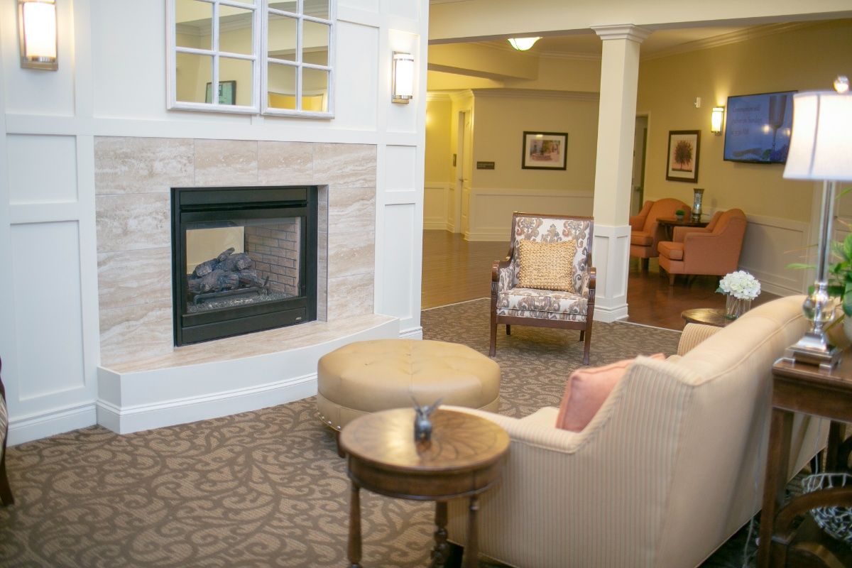 Interior view of The Parkway Senior Living room with modern decor, furniture, and a cozy fireplace.